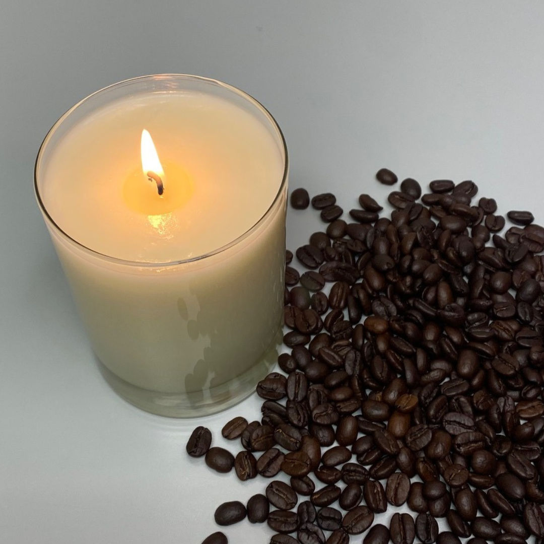 lit soy candle with coffee beans on side