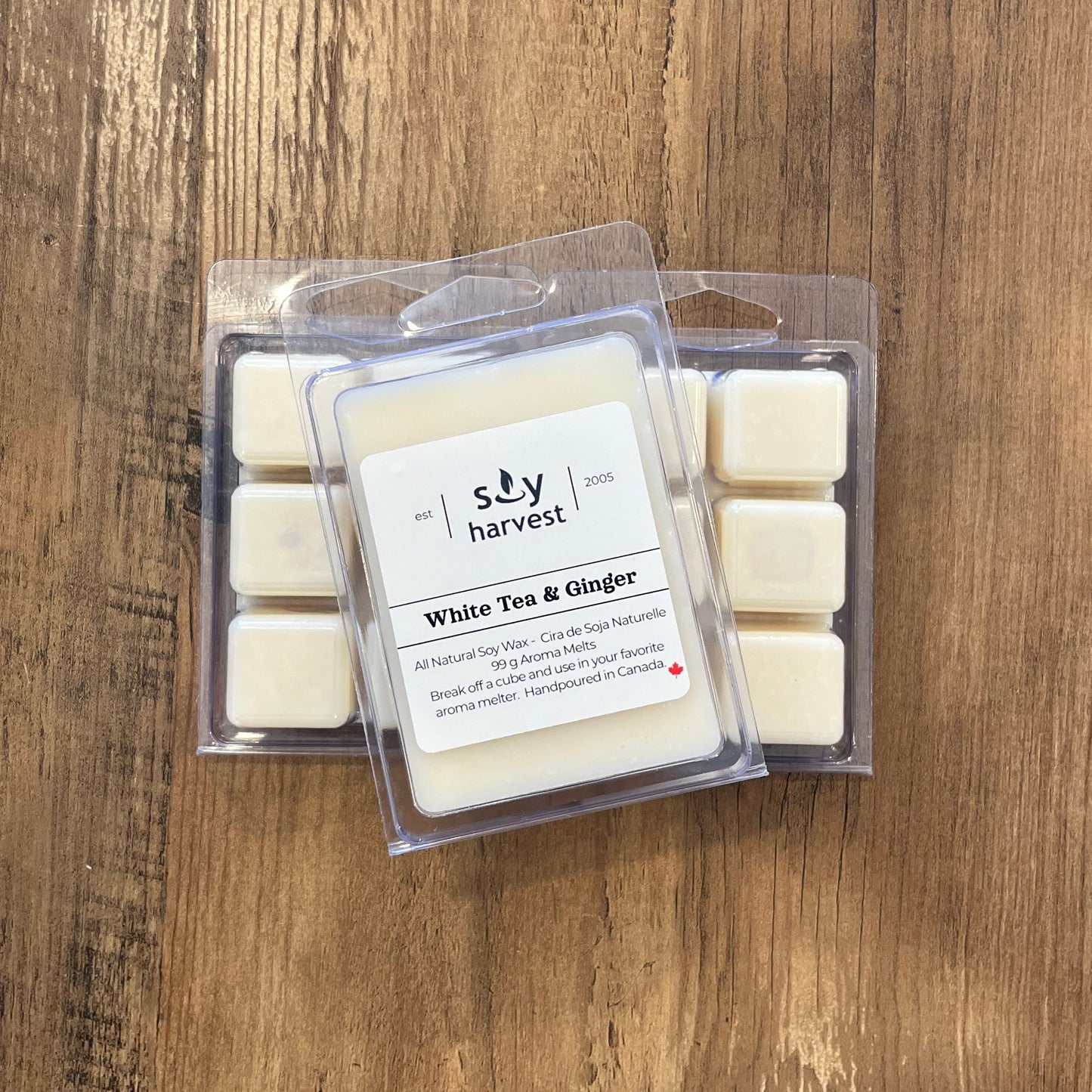 Pack of soy wax melts labeled 'White Tea & Ginger' on a wooden surface