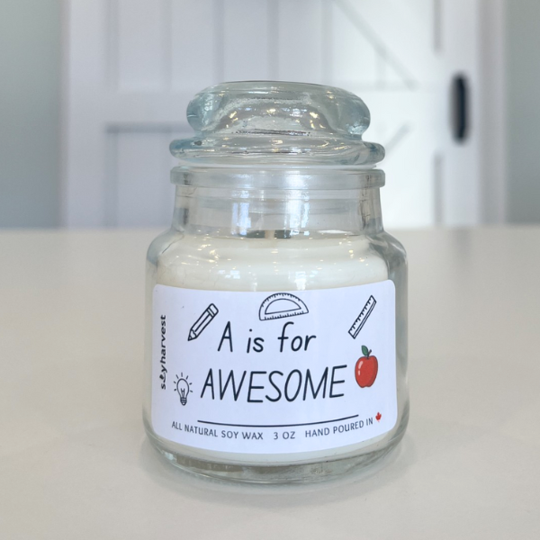 Glass jar candle with 'A is for AWESOME' label on a white surface