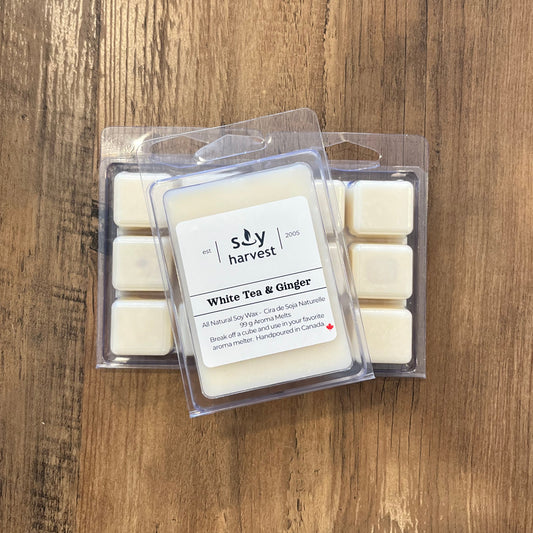 Pack of soy wax melts labeled 'White Tea & Ginger' on a wooden surface